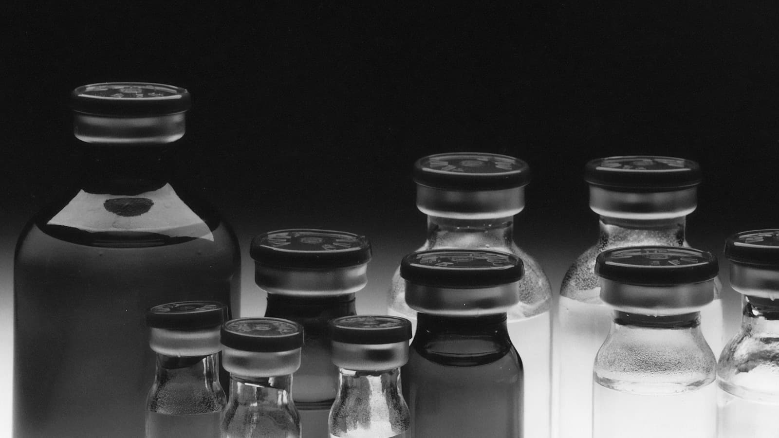 Rows of stoppered glass medication vials of several sizes