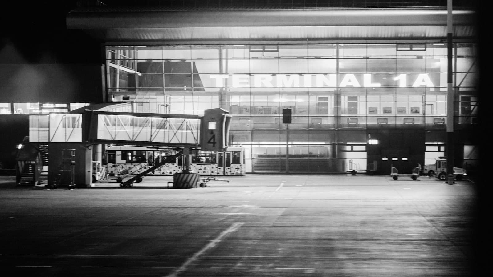 An airport terminal lit up at night, seen from the empty apron